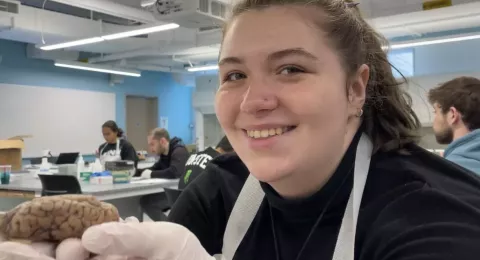 UNH neuroscience and behavior major Amanda Wittemann holding a brain during class